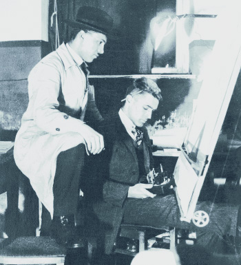 Deux hommes se trouvent dans une pièce. L'un est debout, vêtu d'un manteau clair et d'un chapeau, tandis que l'autre est assis, concentré sur un tableau. Le premier regarde le second, qui tient un objet dans ses mains, probablement une palette ou un pinceau.